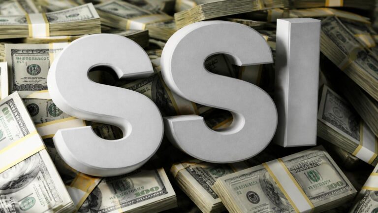 Letras tridimensionales «SSI» colocadas sobre fajos de billetes de 100 dólares apilados.