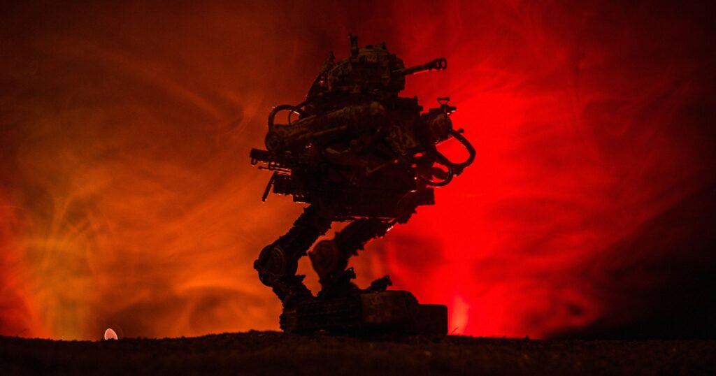 Ilustración de un robot oscuro entre humo sobre un fondo rojo y anaranjado.